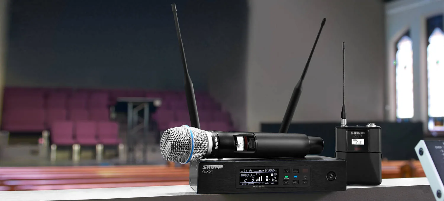 Sistema sem fio digital Shure com microfone de mão sobre o palco de um auditório